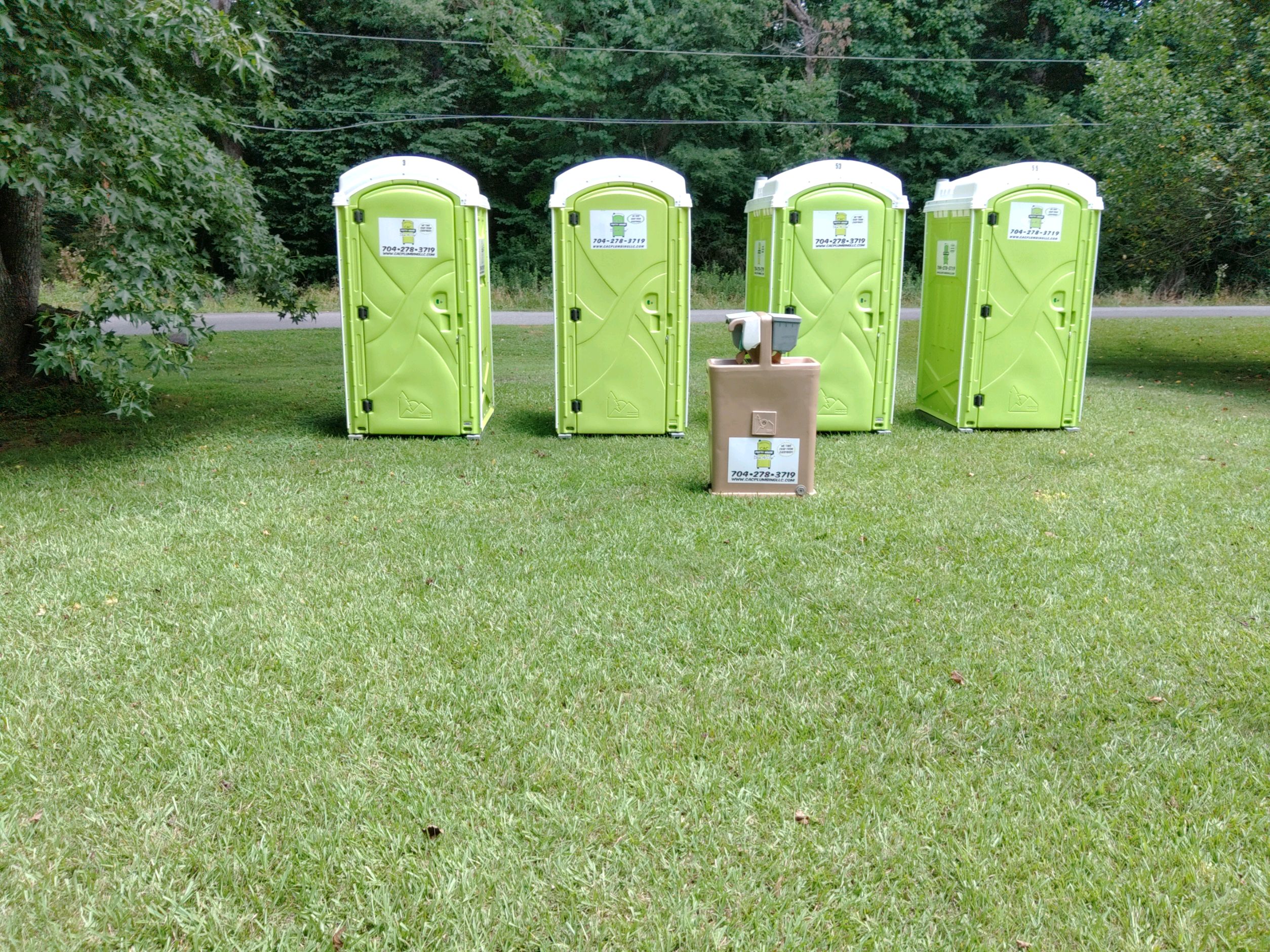 Image of porta johns and a portable sink set up for an event